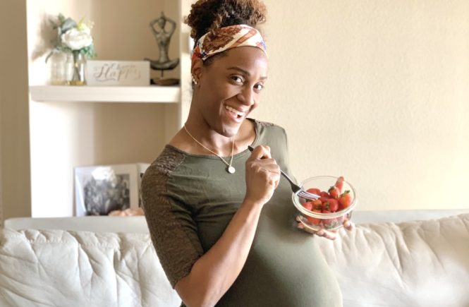 pregnant woman holding eating fruits